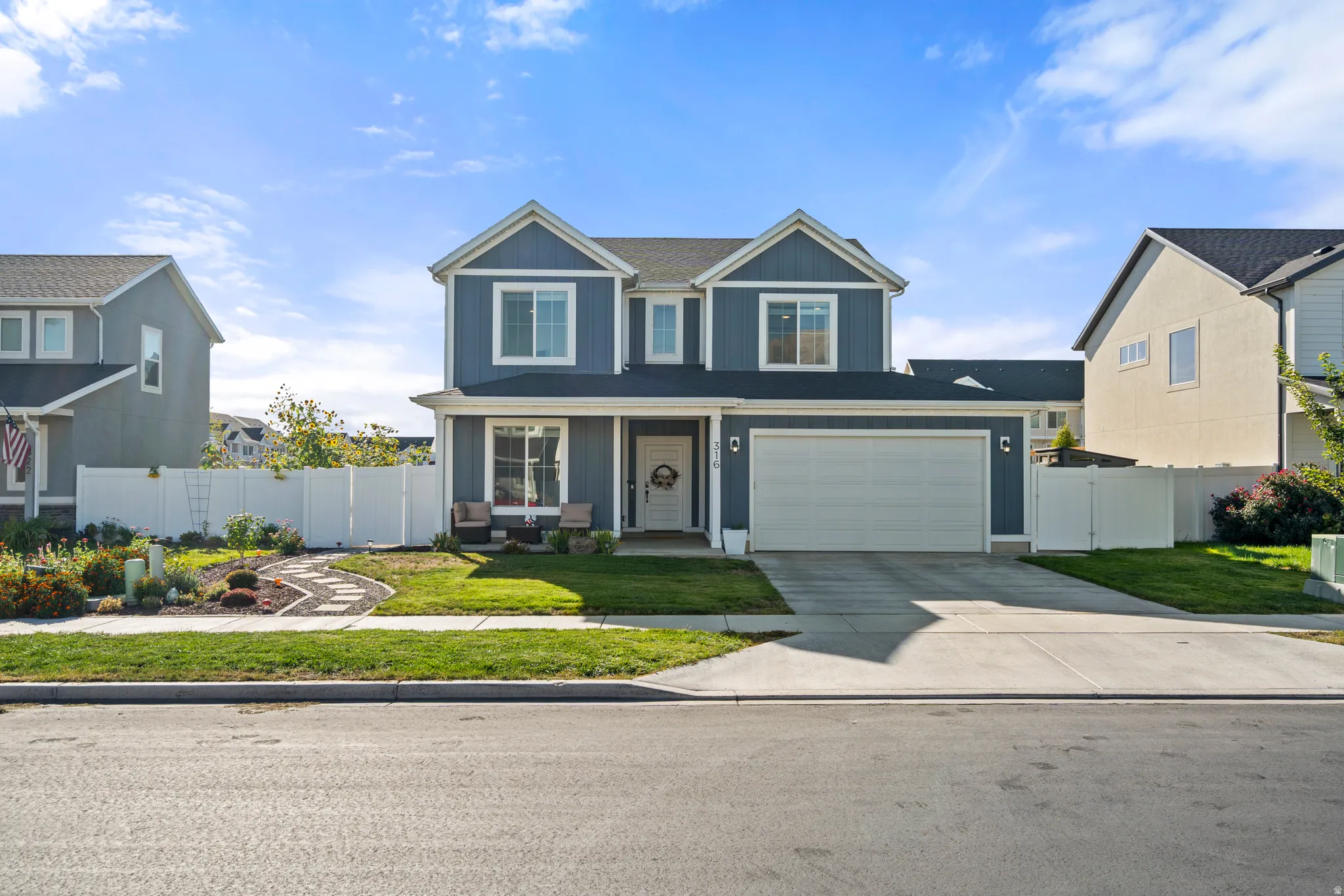 Two-story residence featuring blue siding, white trim, and a white garage door