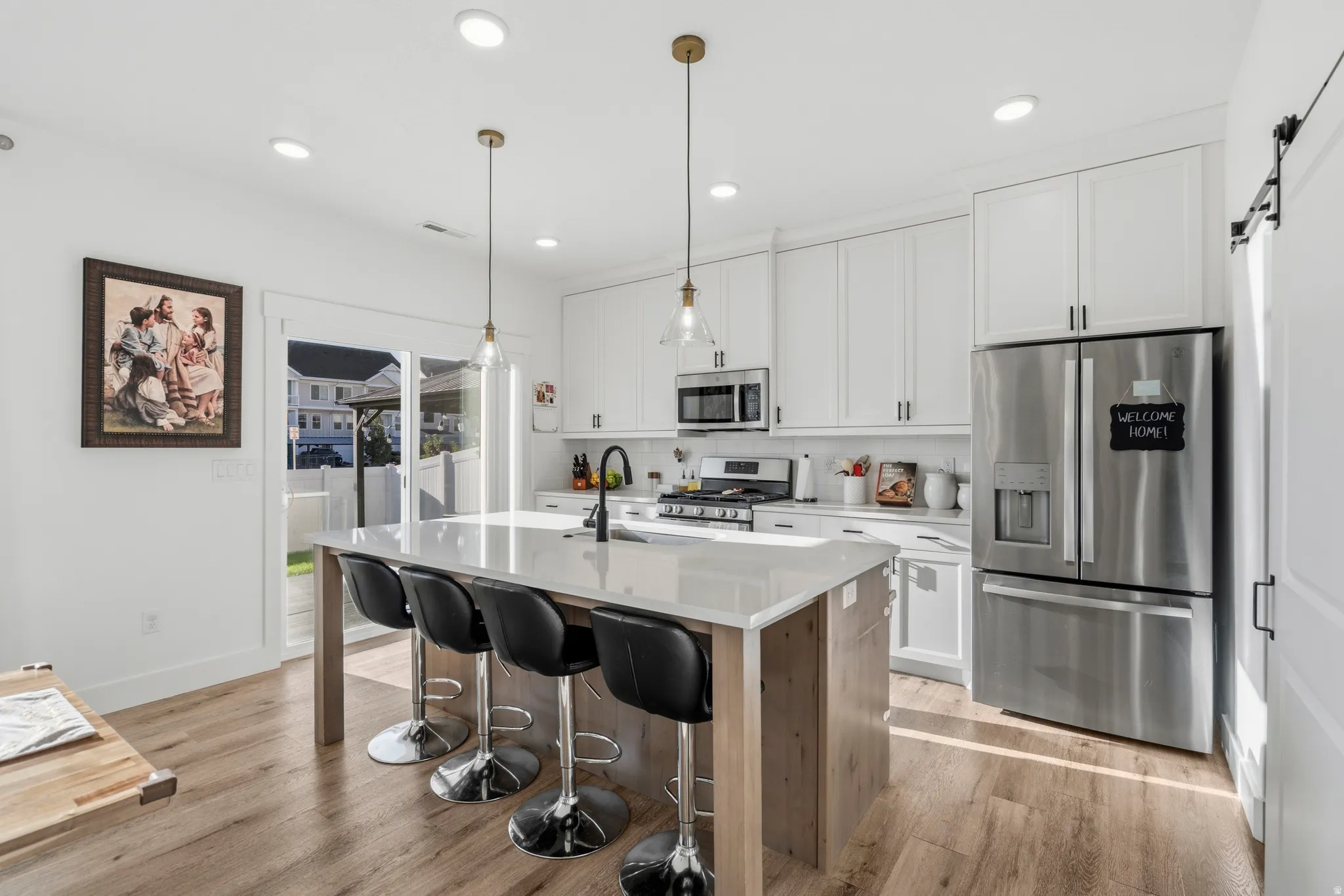 Modern kitchen featuring wood-finish flooring and white cabinetry