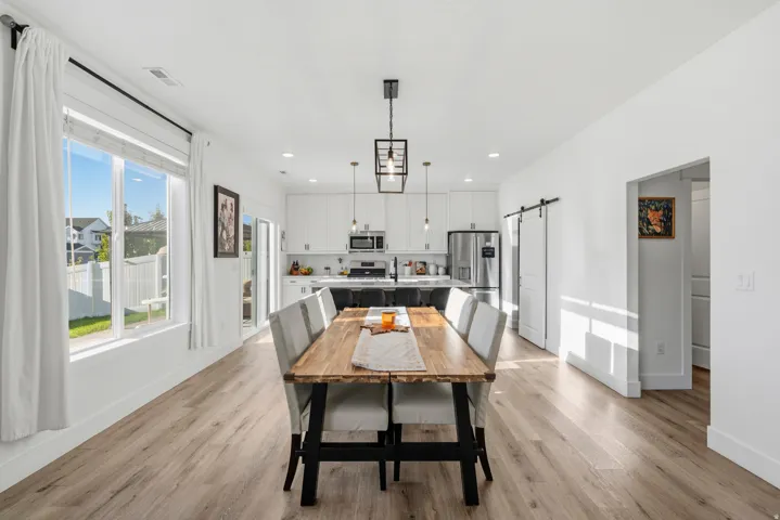Open-concept living space with wood-finish flooring, white walls, and recessed lighting
