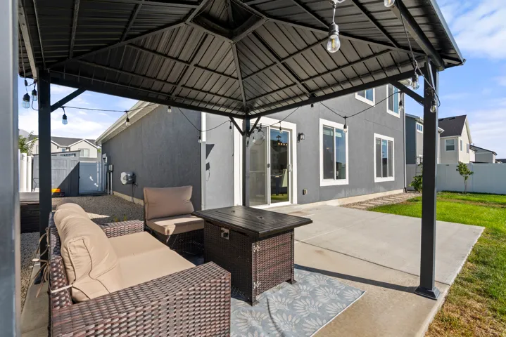 Expansive concrete patio with a detached black metal gazebo