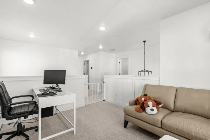 Loft space featuring recessed lighting, carpeting, wainscoting, and a hanging pendant light fixture