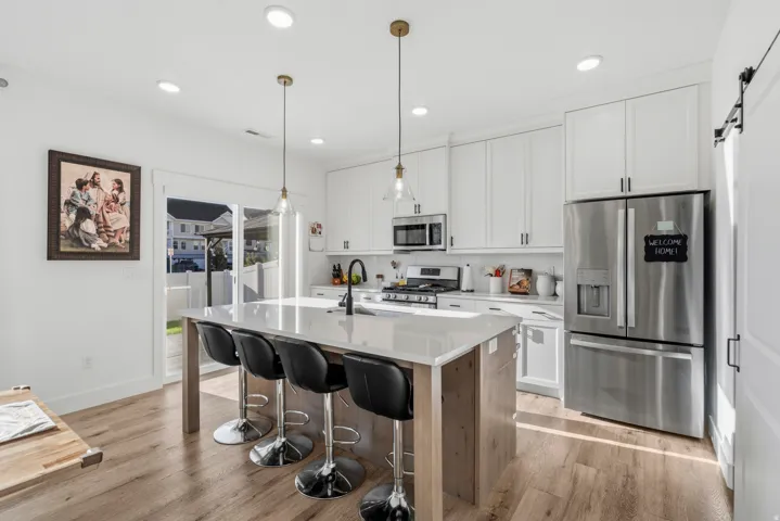 Modern kitchen featuring wood-finish flooring and white cabinetry