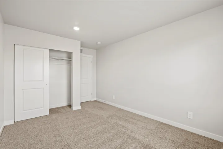Neutral-toned walls, recessed lighting, and soft carpet flooring