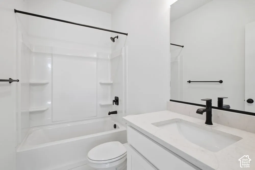 Bathroom featuring a vanity with a white composite countertop, undermount sink, matte black faucet, and a combined tub and shower surround with matte black fixtures