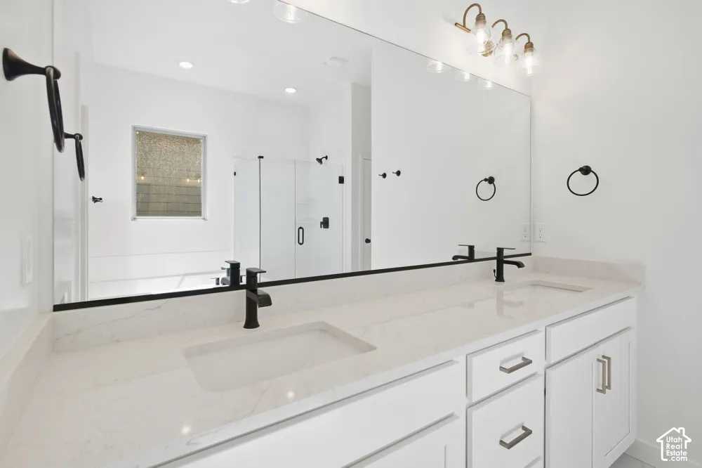 Dual-sink vanity with quartz countertop, matte black fixtures, full-width mirror, and glass-enclosed shower