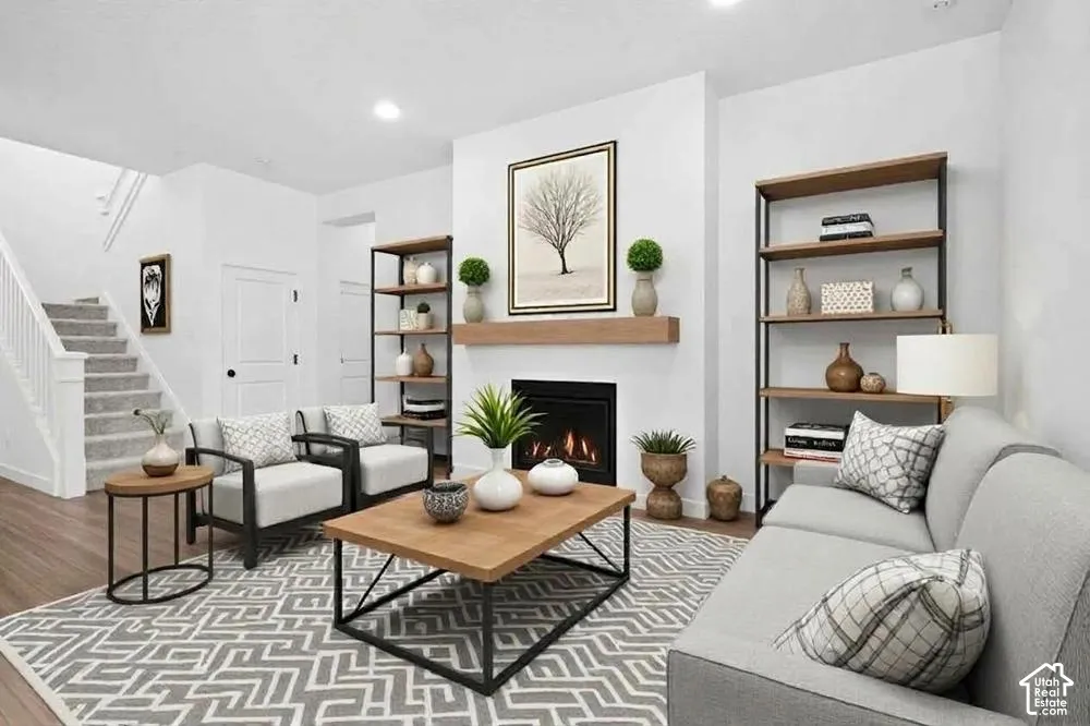 Gas fireplace with a wood-finish mantel, neutral wall-to-wall carpeting, wood-finish flooring, and recessed ceiling lighting