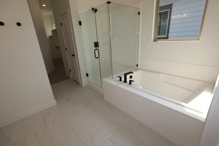 White rectangular soaking tub with matte black fixtures