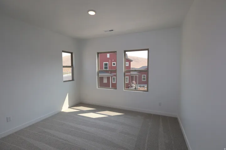Recessed lighting, light-toned carpet, and multiple windows