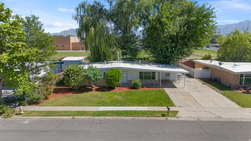Single-story residence featuring a covered carport and a paved driveway