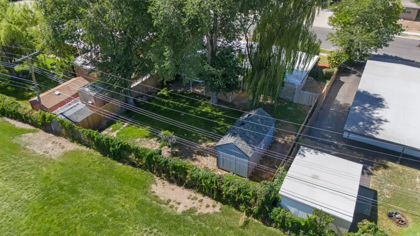 Spacious lot featuring a manicured lawn, established perimeter fencing, and mature trees