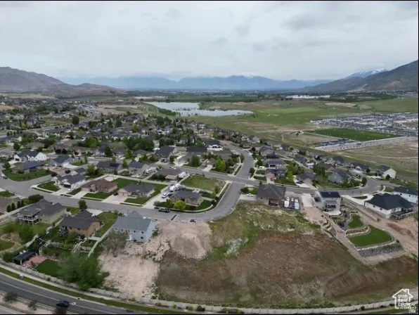 Aerial perspective of a residential neighborhood with distant mountains and a body of water