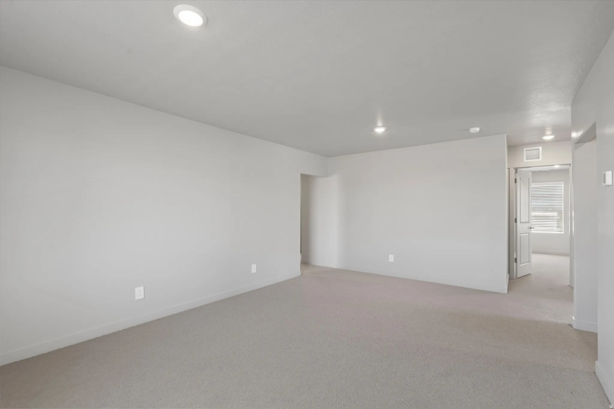 Recessed lighting, light-toned carpeting, neutral wall finishes, and white trim