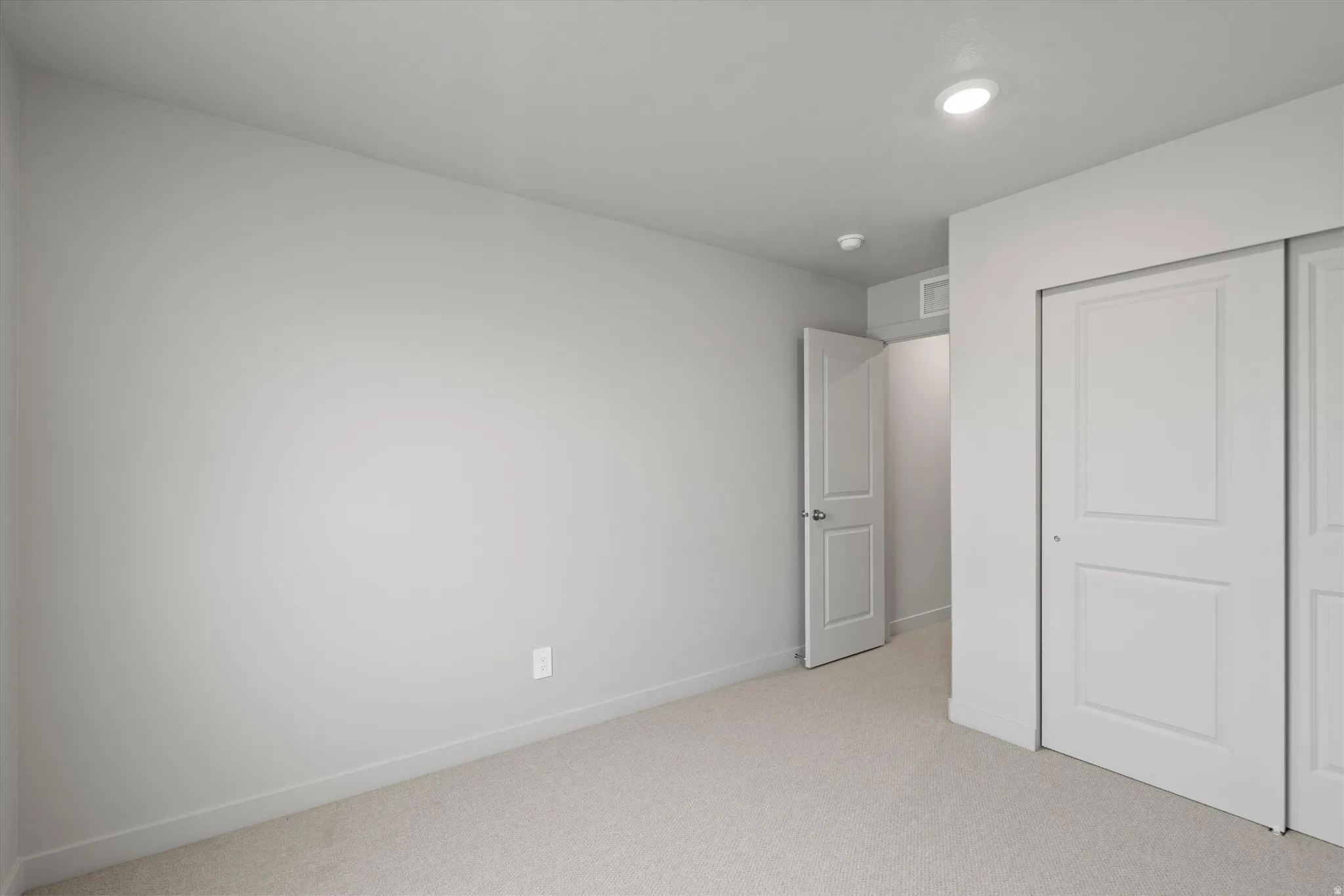 Neutral wall paint, recessed lighting, and carpeted flooring
