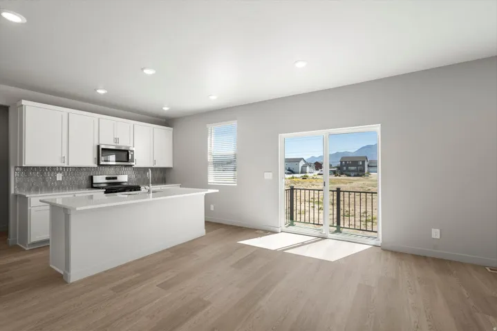 **DISCLIAMER** Some upgrades not photographed. Kitchen with white cabinetry, stainless steel appliances, a white island, and a decorative tile backsplash