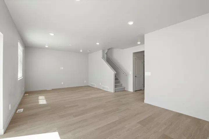 Expansive room featuring wood-finish flooring, recessed lighting, and a neutral wall color