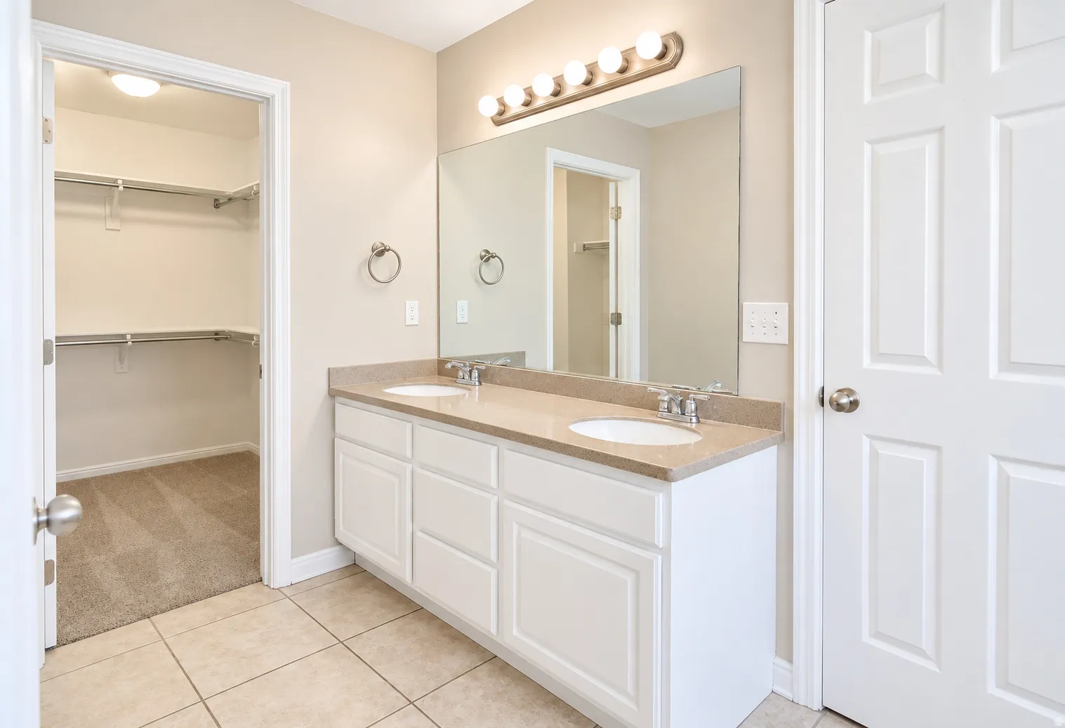 Double vanity with stone-finish countertop, dual undermount sinks, and chrome fixtures