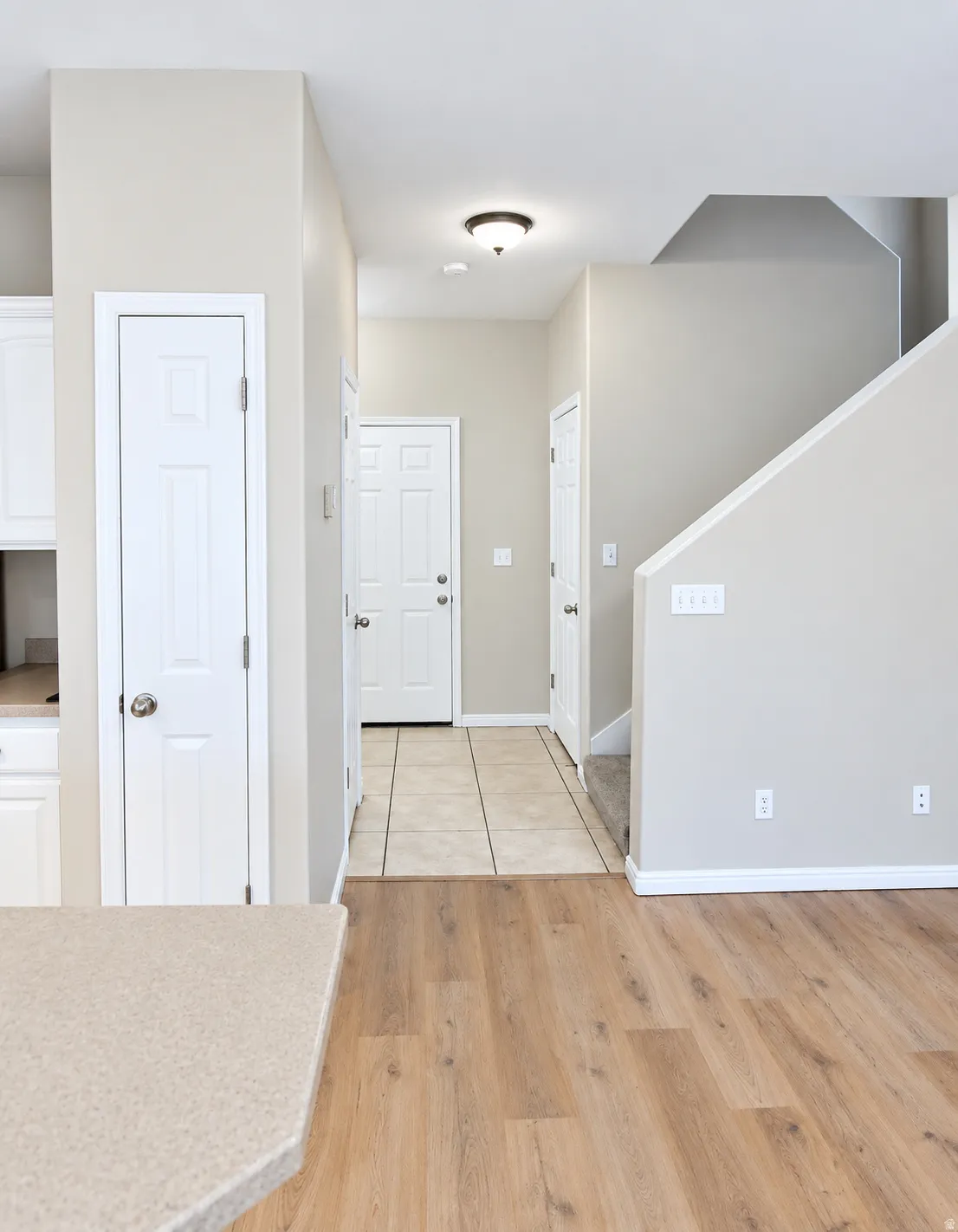 Wood-finish flooring with a tiled entryway