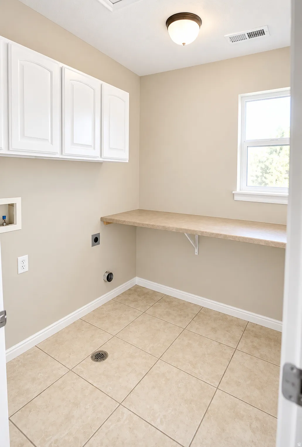 White upper cabinetry, built-in countertop, window, tile flooring, and overhead lighting