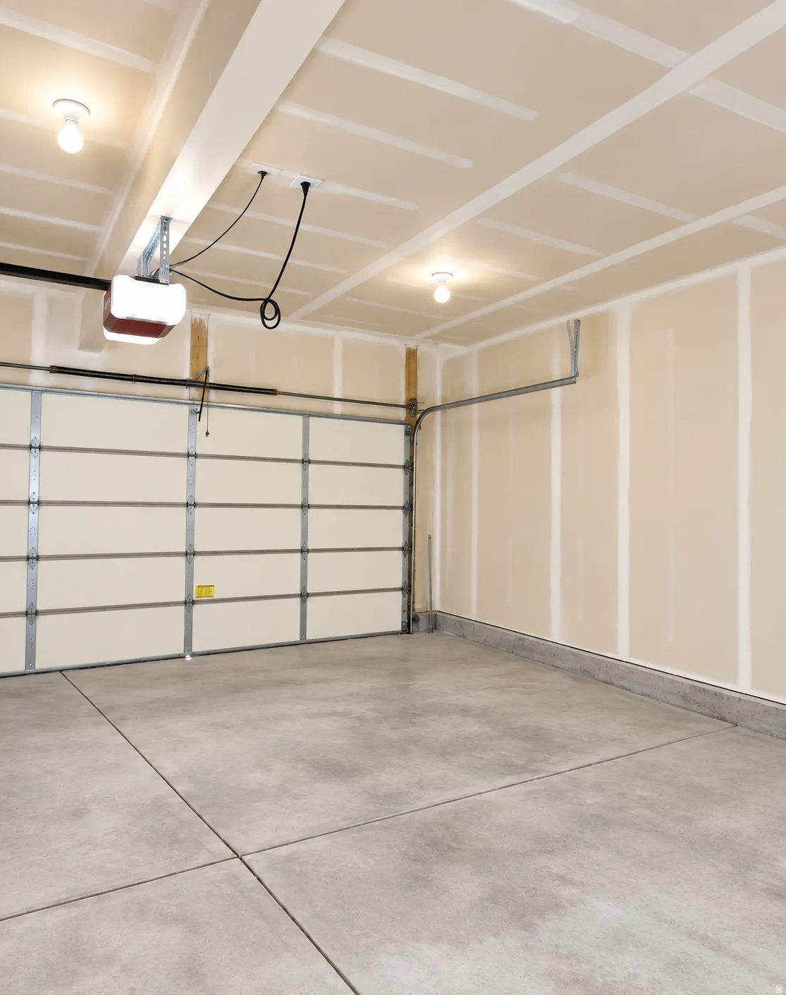 Attached garage with concrete flooring, automatic garage door opener, and overhead lighting
