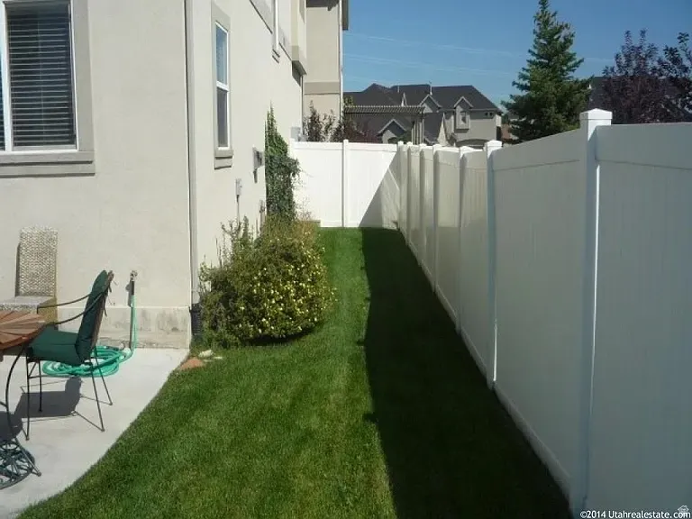 White vinyl privacy fencing with a manicured lawn section