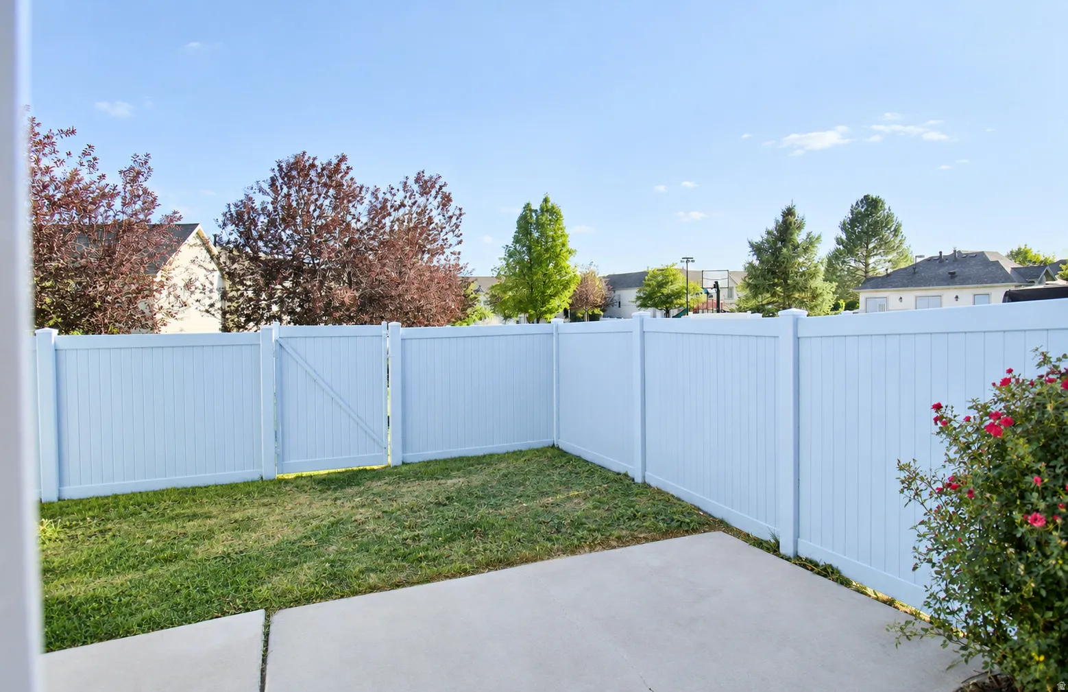 Private backyard with a white panel fence and integrated gate