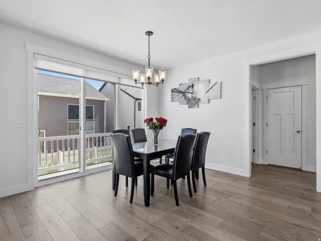 Wood-finish flooring, white trim details, and a sliding glass door to an exterior balcony with white railing
