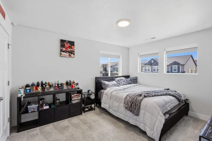 Light gray wall paint, flush mount ceiling light, and three windows with white trim