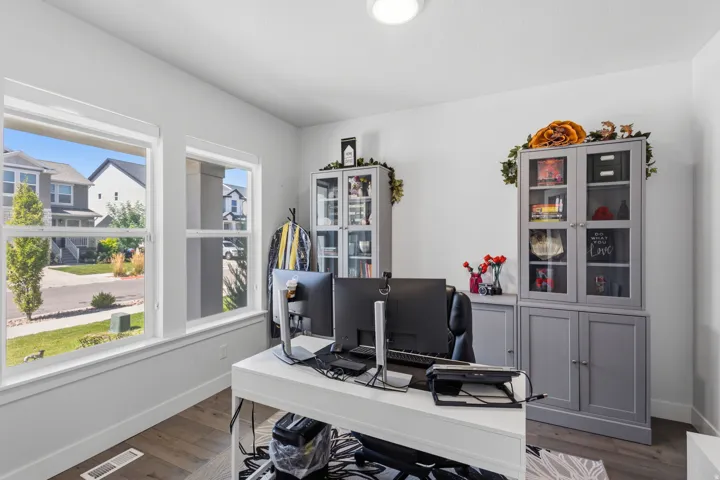 Room with two large windows, wood-finish flooring, and a flush-mount ceiling light