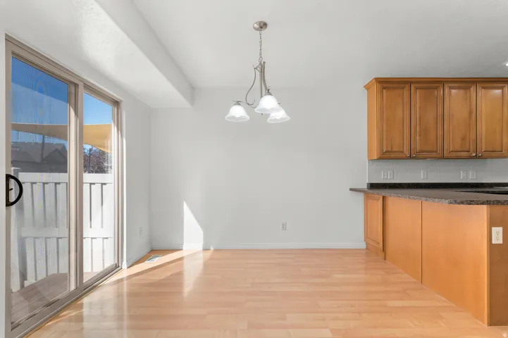 Hardwood flooring, sliding glass door, overhead lighting fixture, wood cabinetry, and solid surface countertops