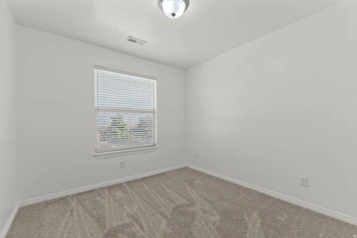 Neutral wall tones with a single window featuring blinds