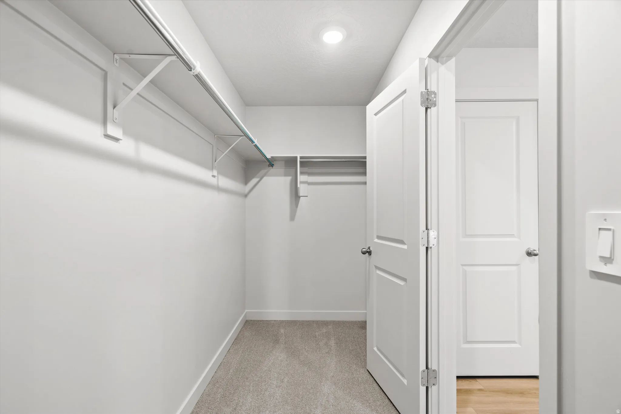 Recessed ceiling lighting, durable carpeting, built-in shelving, and white panel doors