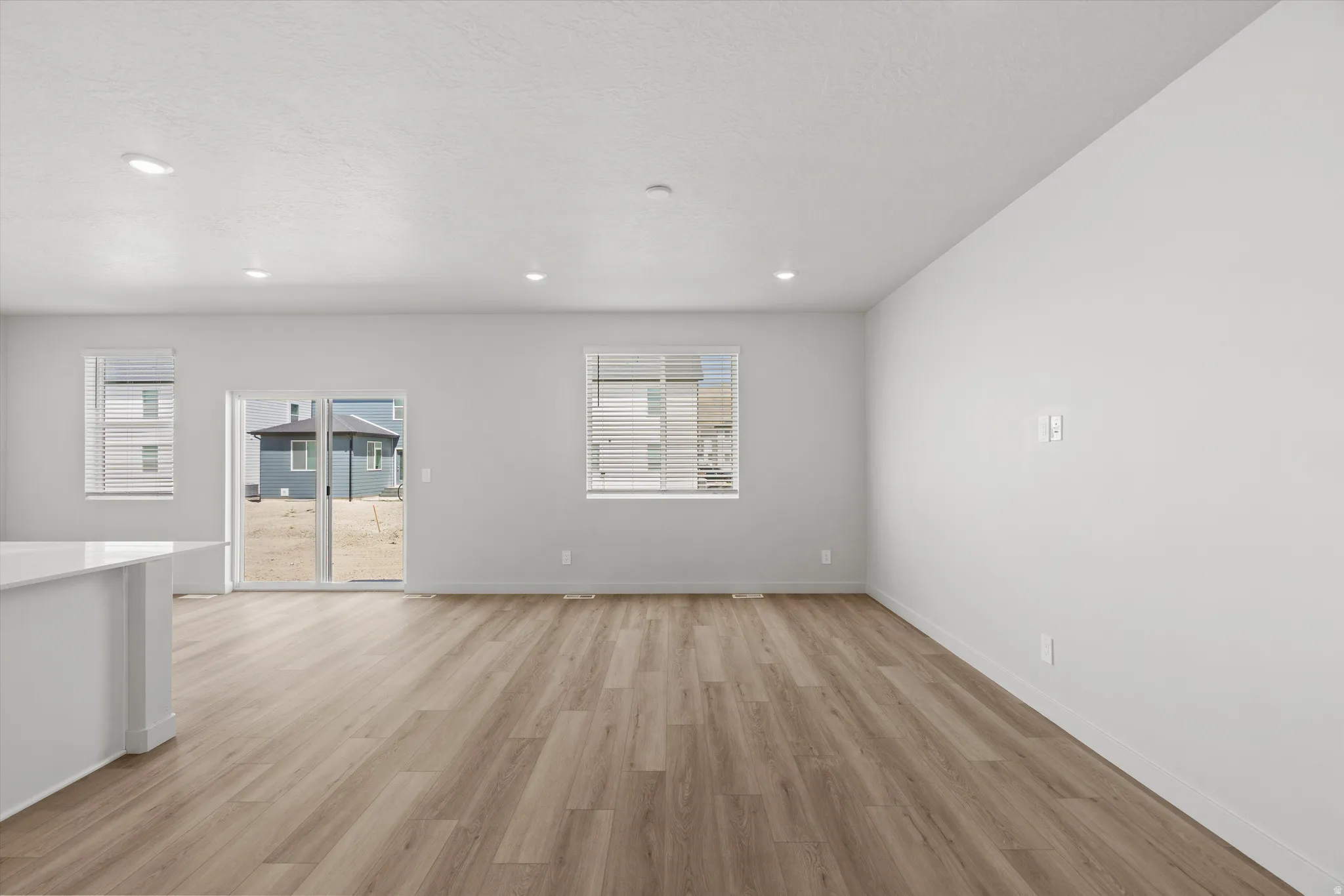 Wood-finish flooring, recessed lighting, and white walls
