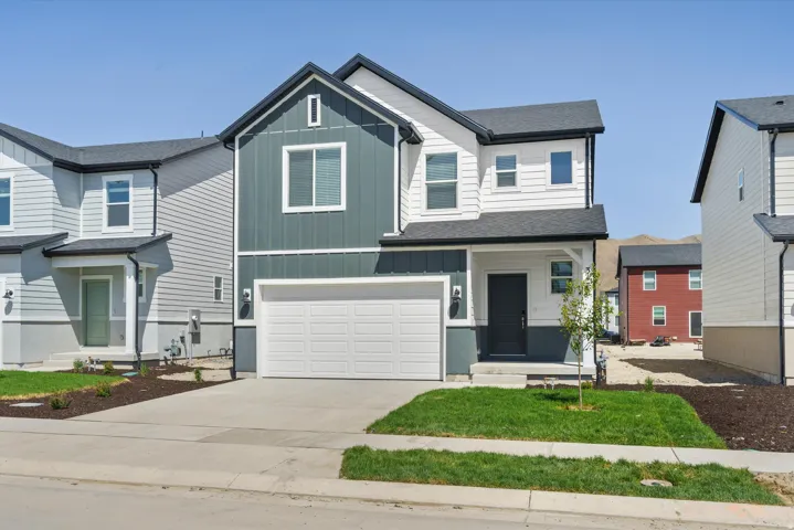 **DISCLAIMER** Elevation may vary.  Two-story residence featuring a two-car garage, dark gray siding accents, and a dark asphalt shingle roof