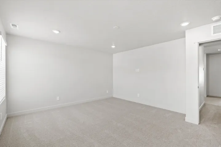 Recessed ceiling lighting, light gray wall paint, gray carpet flooring, white trim, and a window with blinds
