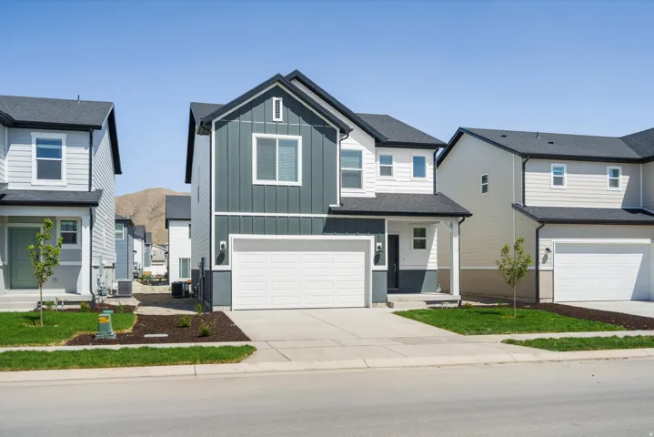 **DISCLAIMER** Elevation may vary.  Two-story residence featuring a two-car garage, dark-pitched roof, and a combination of vertical and horizontal siding