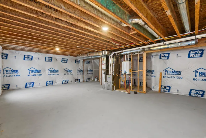 Unfinished basement with exposed wood joists and concrete flooring