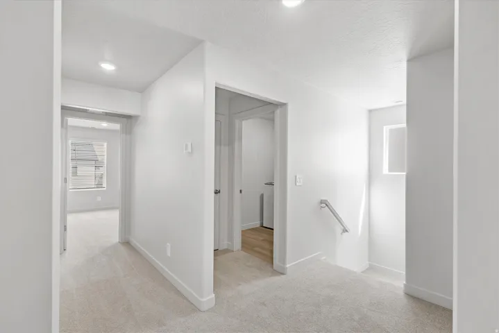 Recessed lighting, light-toned carpeting, and a built-in handrail