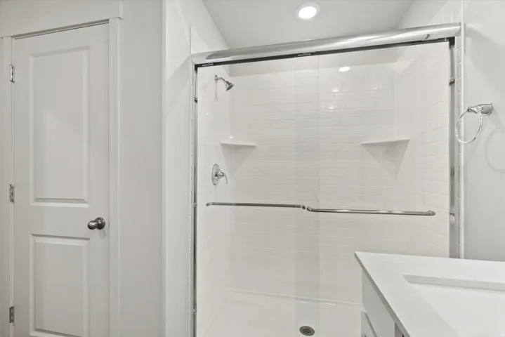 Shower with frameless glass enclosure and subway tile surround