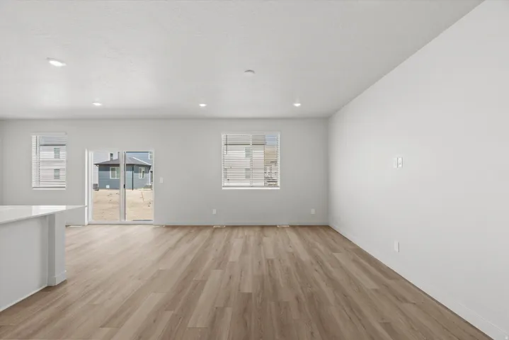 Wood-finish flooring, recessed lighting, and white walls