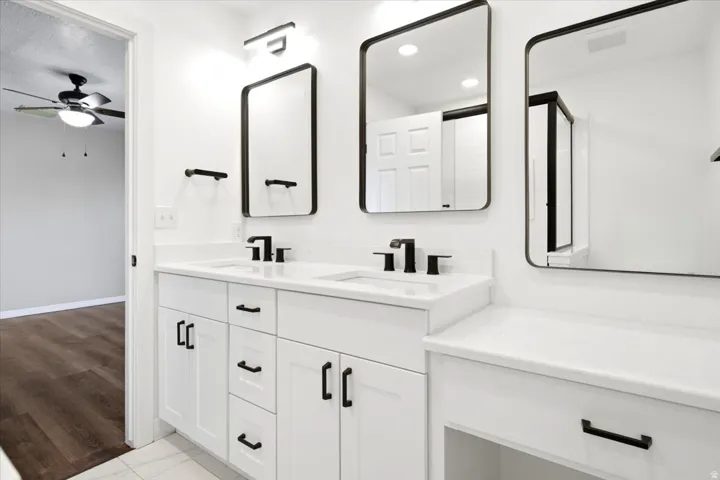 Dual vanity with white cabinetry, matte black hardware, and rectangular mirrors