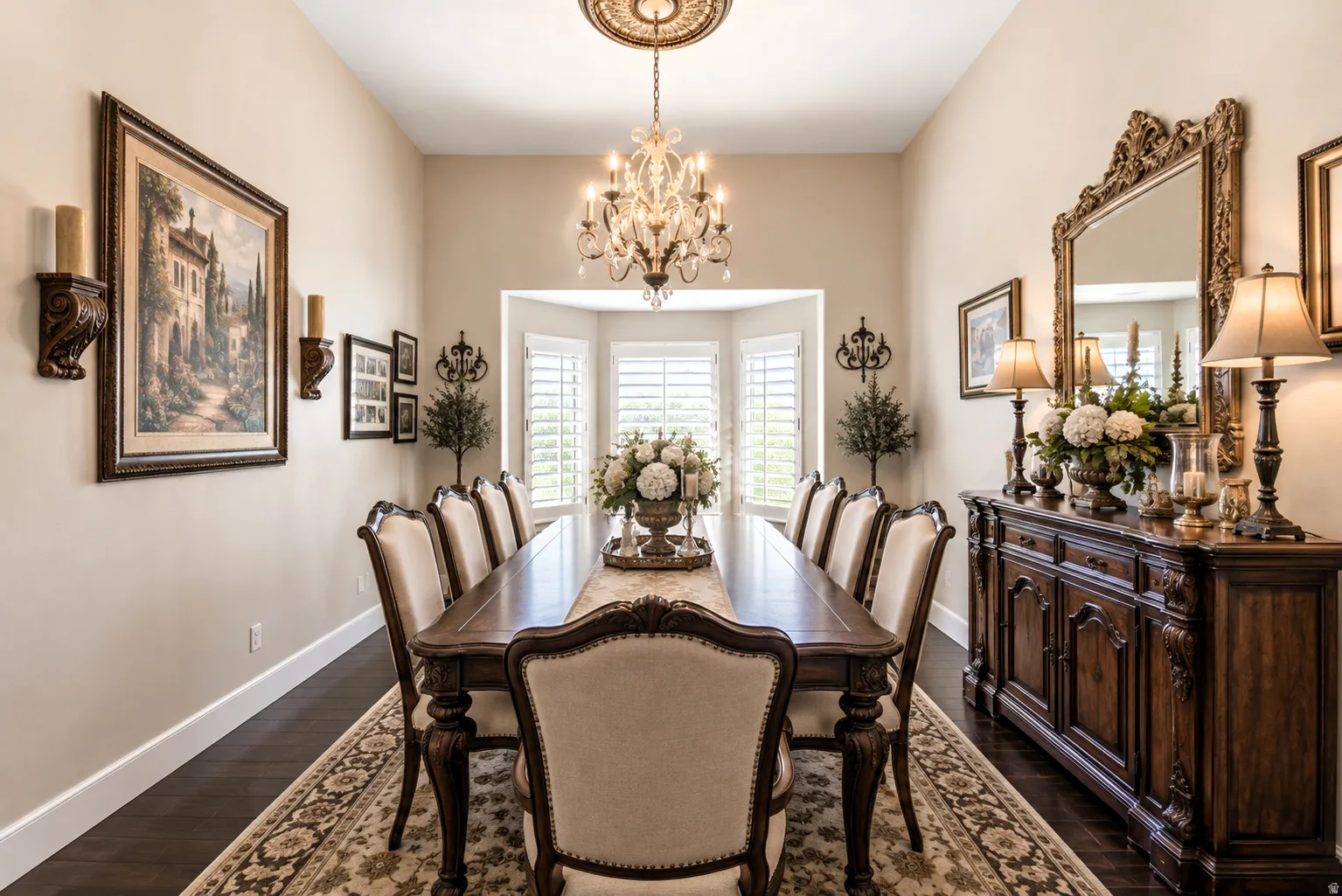 Digitally altered to show how you can either have a formal living or formal dining space that features dark wood-finish flooring, a bay window with plantation shutters, a chandelier with ceiling medallion, and neutral wall tones.