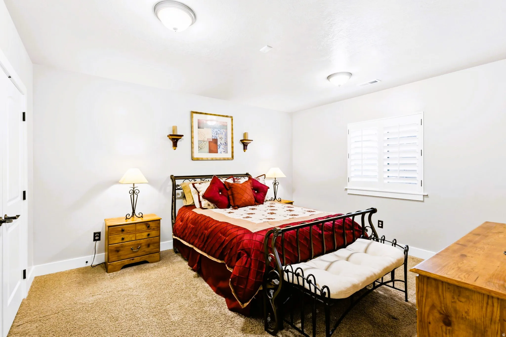 Bedroom #5, featuring light colored walls, plantation shutters and carpet.