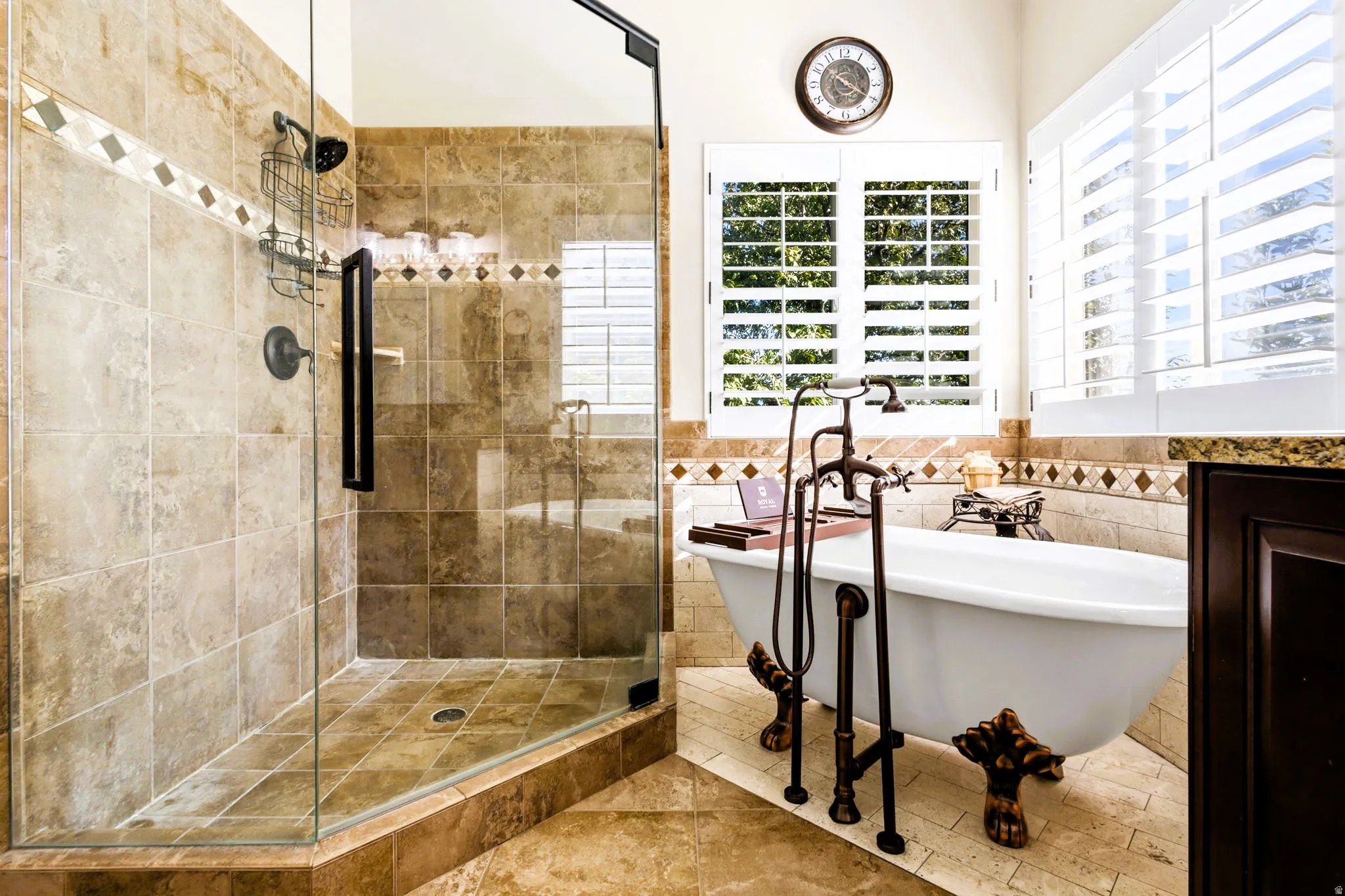 Primary bath, Euro Glass enclosed shower with tiled walls and flooring, and free-standing claw tub.