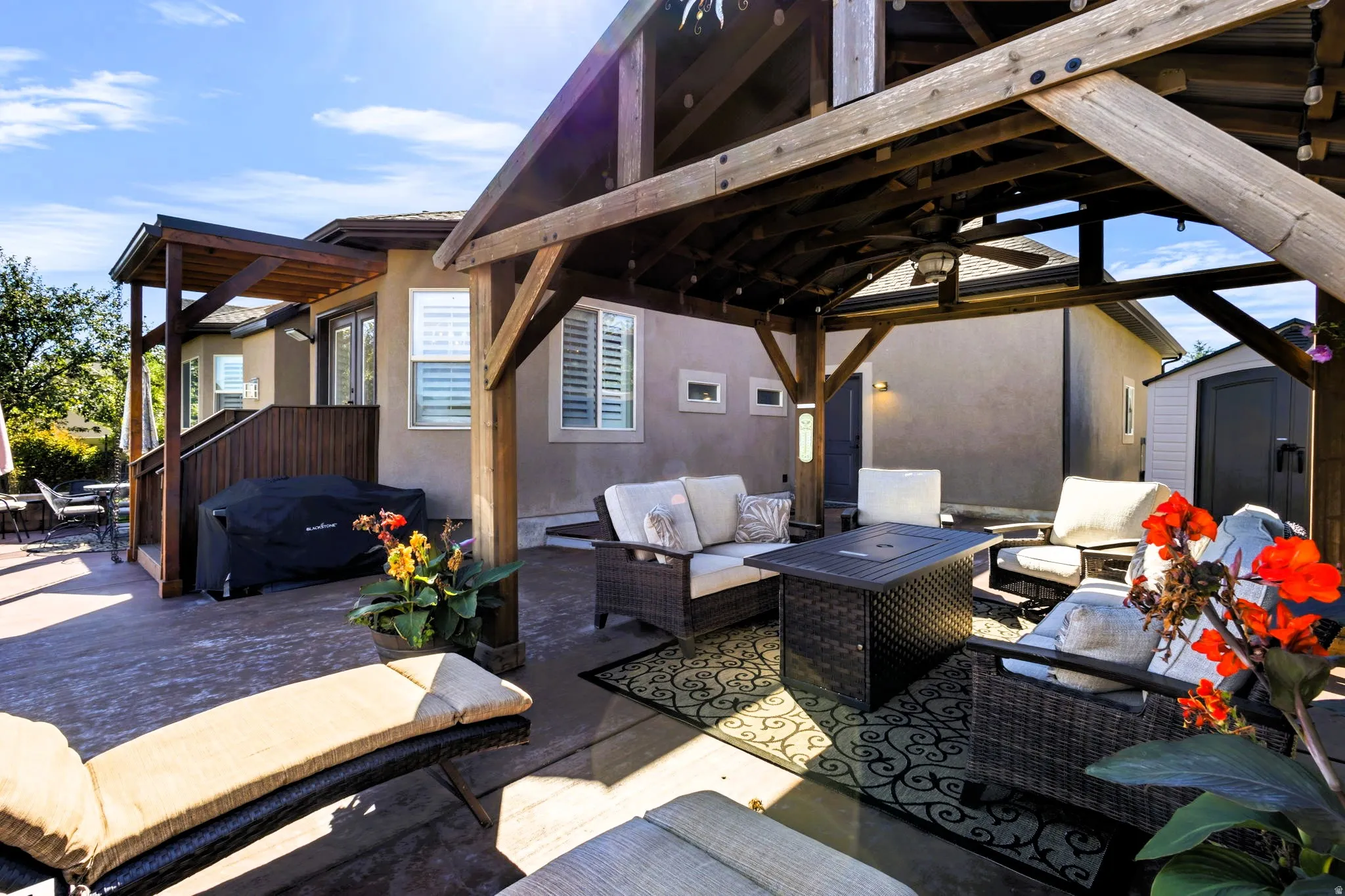 Expansive outdoor patio featuring a wooden gazebo, a built-in pergola, and exterior shed.