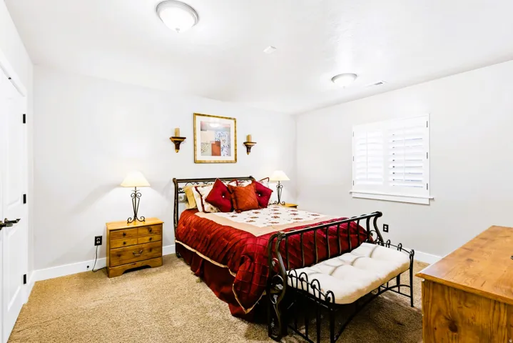 Bedroom #5, featuring light colored walls, plantation shutters and carpet.