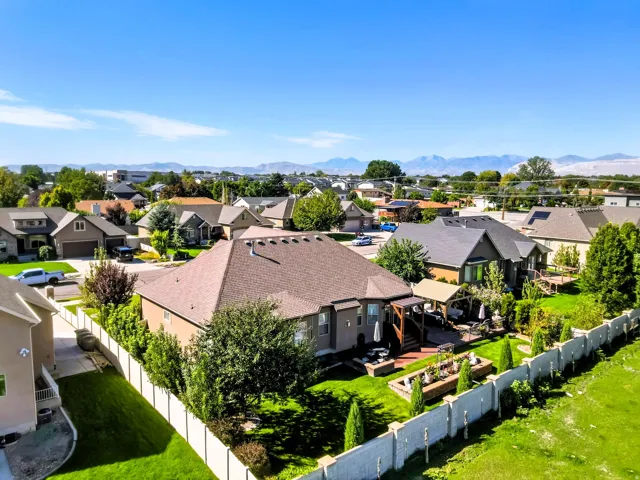 Expansive backyard featuring a manicured lawn, built-in planters, and a covered patio structure