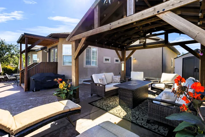 Expansive outdoor patio featuring a wooden gazebo, a built-in pergola, and exterior shed.