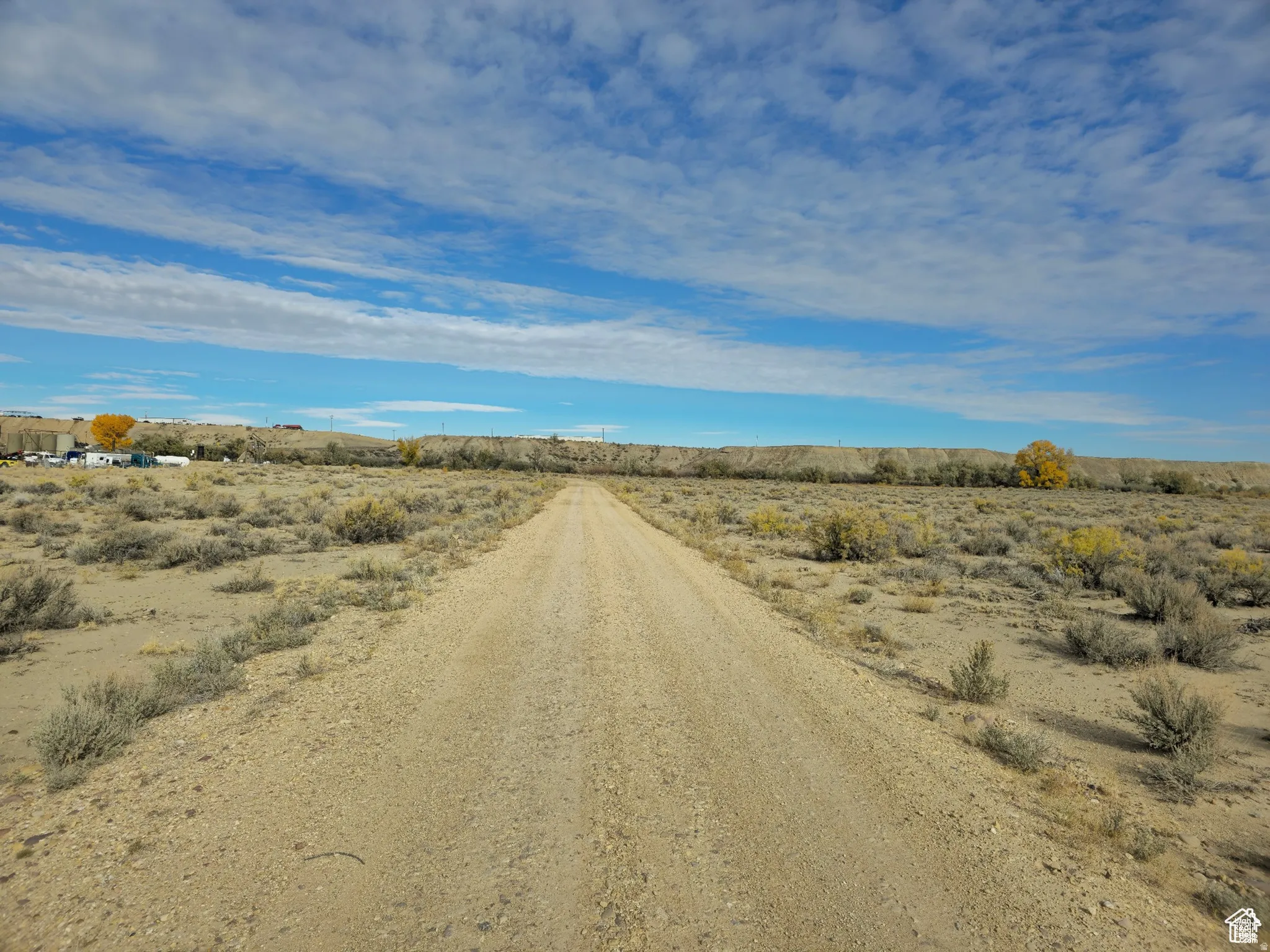 Expansive open land with a gravel road and natural desert vegetation
