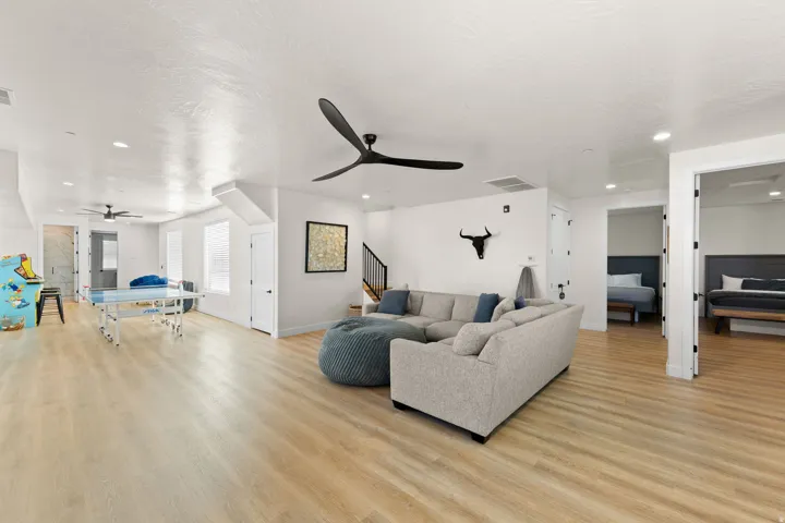 Spacious common area featuring light wood-finish flooring, recessed lighting, and multiple ceiling fans