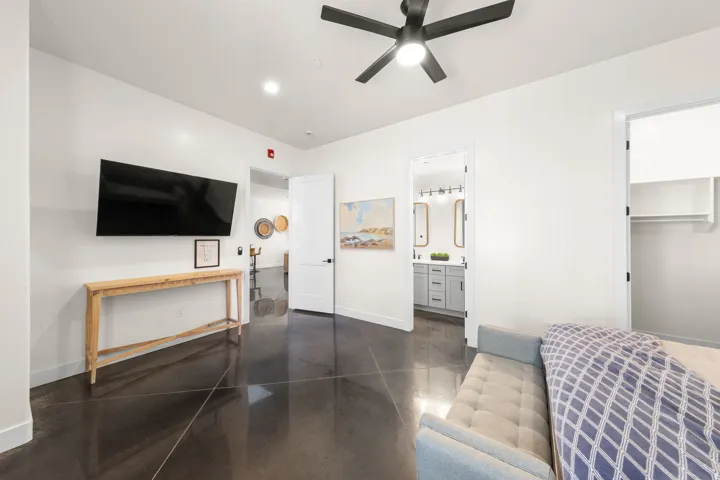 Polished concrete flooring, recessed lighting, and a contemporary ceiling fan